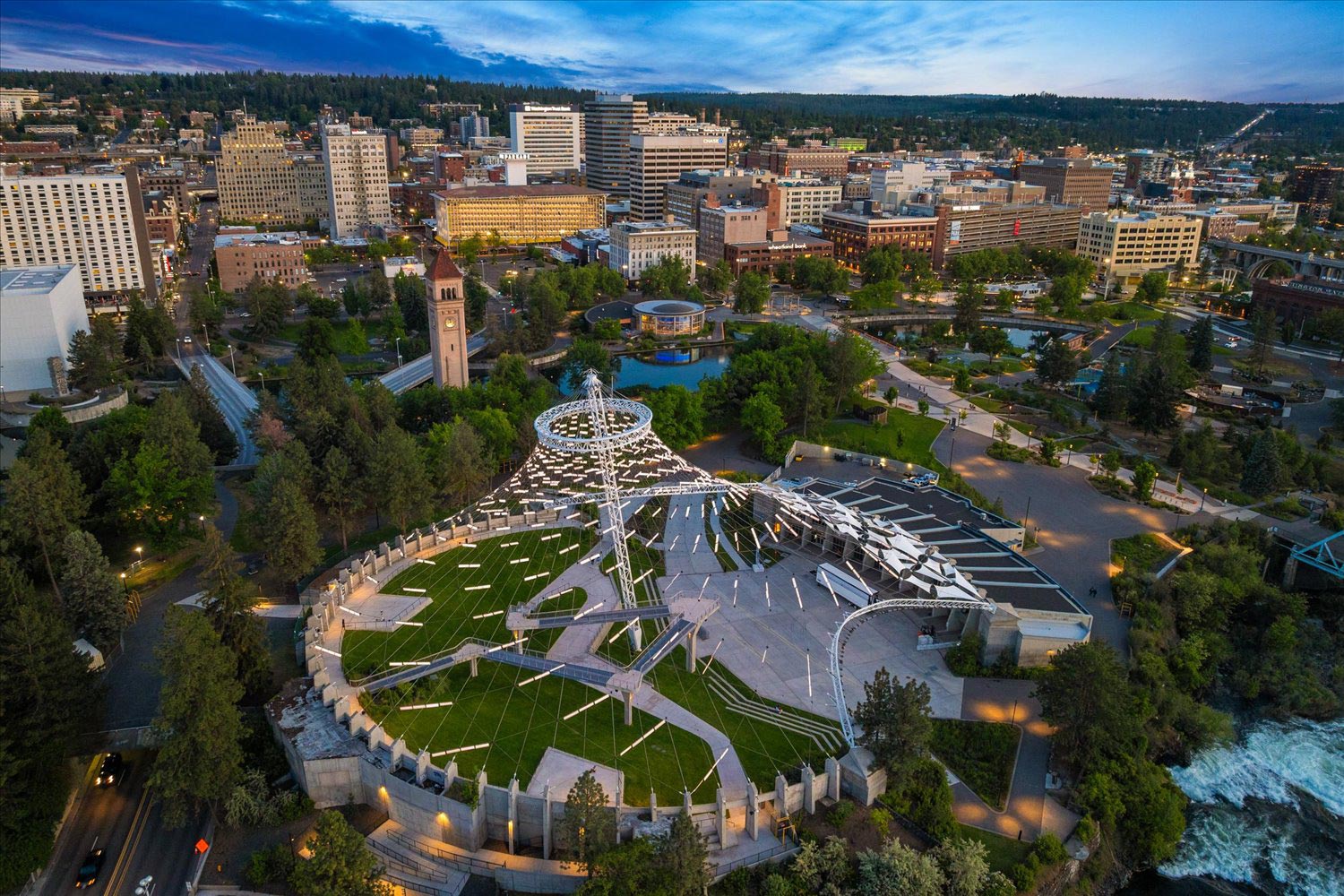 Aerial view of downtown Spokane, Washington at dusk showing the Riverfront Park pavilion and city skyline